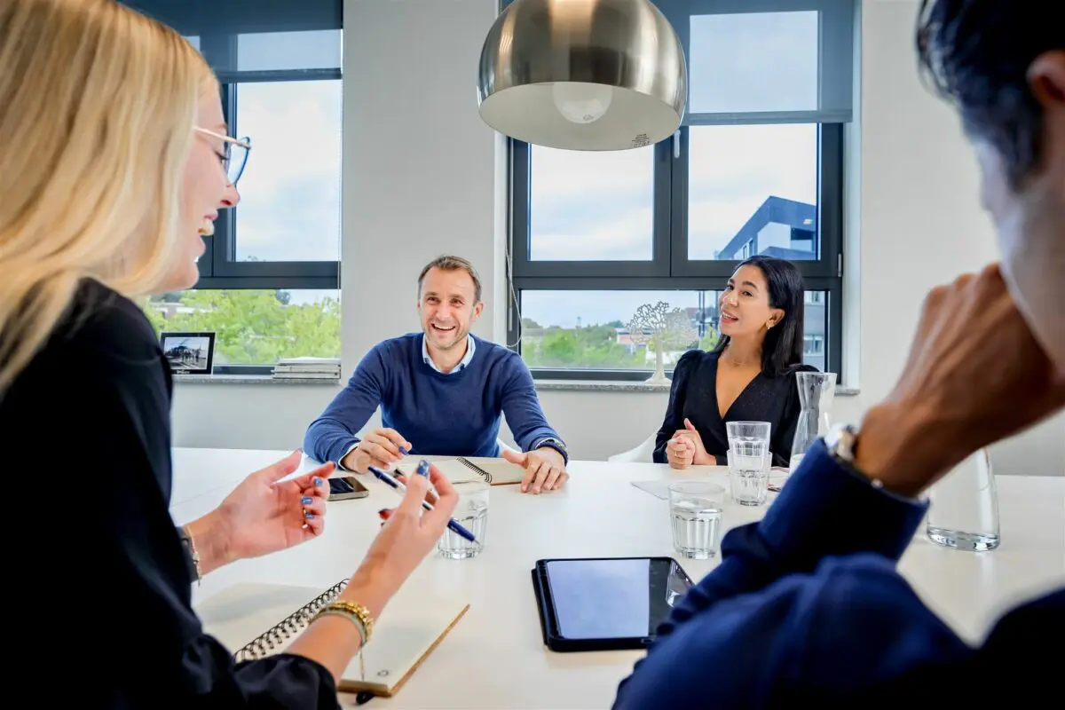 Team Proud People lachend in een overleg
