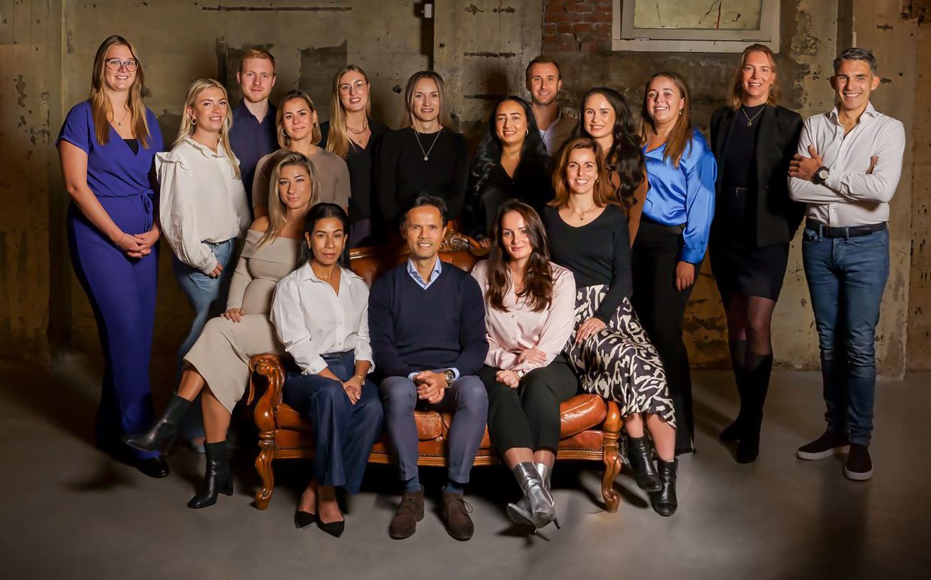 Groepsfoto Proud People recruitmentbureau Finance alle werknemers kijken lachend in de camera