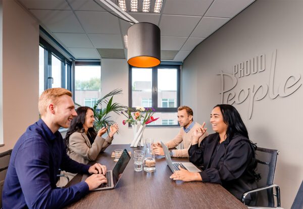 Zijaanzicht vier collega's met elkaar in gesprek